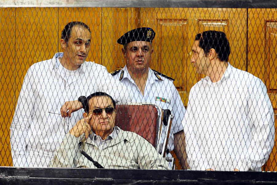 Бывший президент Египта Хосни Мубарак (сидит) и два его сына Гамаль Мубарак (слева) и Алаа Мубарак (справа) на судебном заседании в Каире, 2014 год