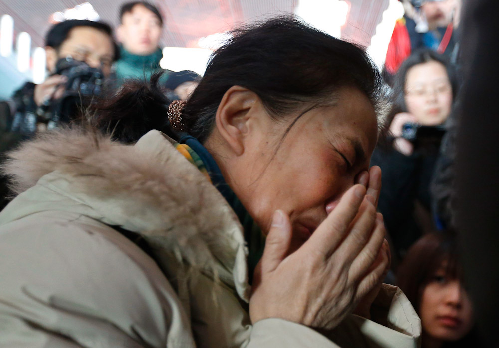 Родственники пассажиров, находившихся на борту рейса MH370 компании Malaysian Airlines, в аэропорту Пекина