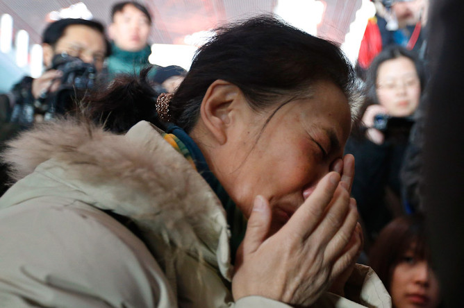 Родственники пассажиров, находившихся на борту рейса MH370 компании Malaysian Airlines, в аэропорту Пекина