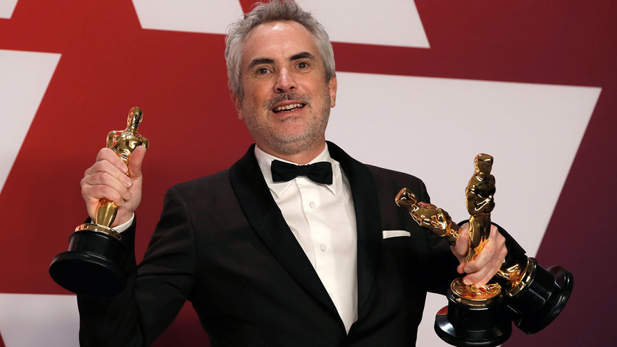Альфонсо Куарон с наградами во время церемонии вручения кинопремии «Оскар» в Лос-Анджелесе, 24 февраля 2019 года