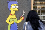 Мурал «Стрижка» художника Александро Паломбо, изображающий героиню культового мультсериала Мардж Симпсон, перед консульством Ирана в Милане, Италия, 5 октября 2022 года