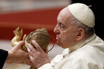 Папа Франциск целует статую Младенца Иисуса во время рождественской мессы в базилике Святого Петра в Ватикане, 24 декабря 2022 года