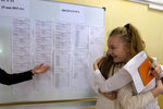 Школьницы у информационного стенда во время проведения единого государственного экзамена по литературе и географии в одной из школ Москвы