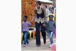 В демократичной блузке ASOS Africa, брюках и жилете J Crew в общинном центре Йоханнесбурга в июне 2011 года