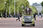 Британский комик Роуэн Аткинсон движется на автомобиле своего персонажа по улице Мэлл
