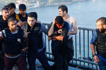 Полицейские защищают военнослужащего от толпы на мосту Босфор в Стамбуле после попытки переворота