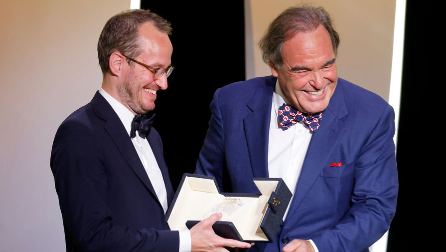 Оливер Стоун вручает Гран-при Каннского кинофестиваля финскому режиссеру Юхо Куосманену за фильм «Купе номер шесть», 17 июля 2021 года