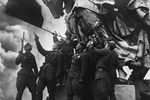 Советские воины салютуют Красному знамени, водруженному на здании Рейхстага, 9 мая 1945 года