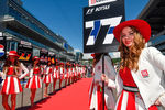 Девушки держат таблички с номерами мест гонщиков на трассе перед гонкой на российском этапе чемпионата мира по кольцевым автогонкам в классе «Формула-1»