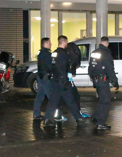 Полиция выводит преступника из здания клиники Schlosspark-Klinik