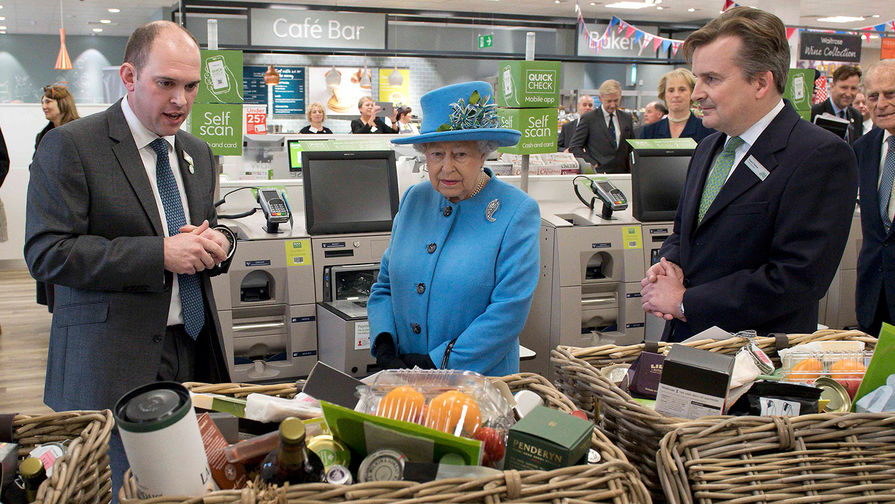 Королева осматривает продуктовые корзины во время посещения магазина