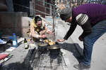 Жители Мариуполя готовят еду на улице во дворе одного из домов, апрель 2022 года