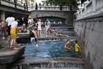 Дети купаются в фонтанах на Манежной площади в жаркую погоду в Москве, 26 июня 2022 года