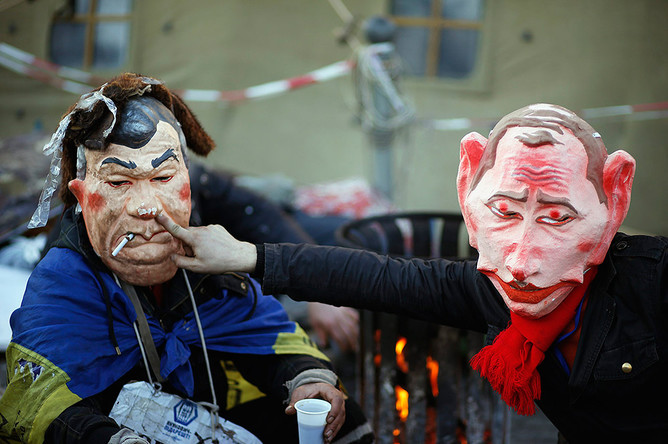 Люди на Майдане в масках Путина и Януковича
