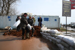 Местные жители укладывают мешки с песком для защиты домов от подтоплений на Уральской улице в Оренбурге, 12 апреля 2024 года