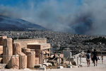 Туристы осматривают Древний Акрополь несмотря на дым от пожаров