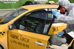 Сотрудник компании во время дезинфекционной обработки автомобилей такси