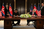Высший руководитель КНДР Ким Чен Ын и президент США Дональд Трамп во время подписания документов на встрече в Сингапуре, 12 июня 2018 года
