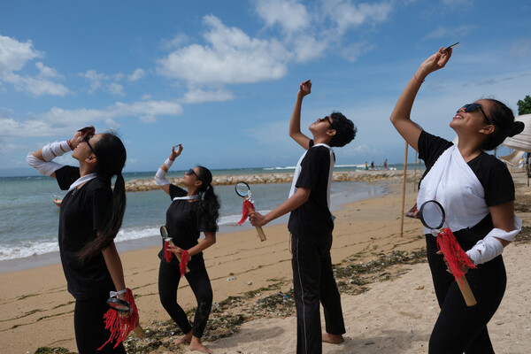 Люди наблюдают редкое гибридное солнечное затмение на&nbsp;пляже в&nbsp;Денпасаре, Бали, Индонезия, 20&nbsp;апреля 2023&nbsp;года
