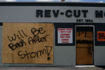 Надпись «Вернемся после урагана» на одной из заколоченных витрин 