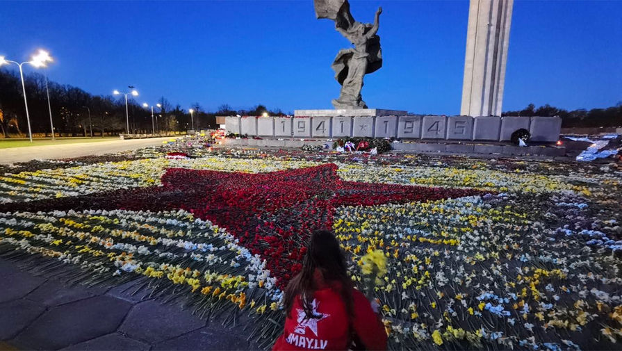 Волонтеры выложили ночью ковер из цветов около памятника освободителям Риги