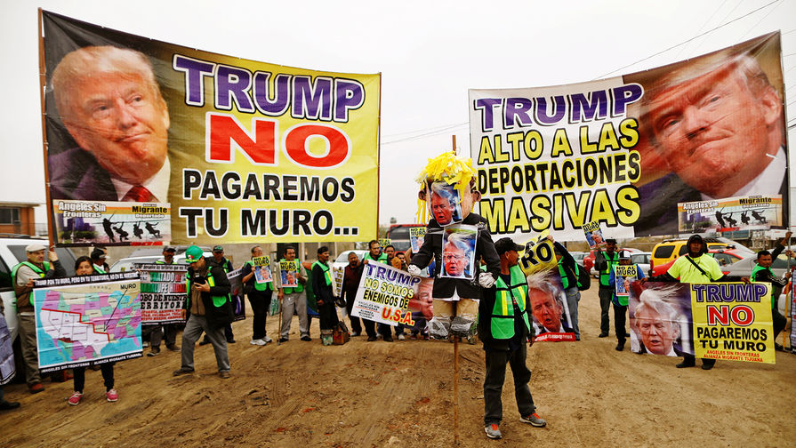 Плакаты «Трамп, мы не будем платить за стену» и «Трамп, останови массовые депортации» около границы США и Мексики в Тихуане, март 2018 года