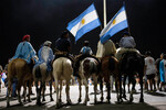 Мужчины, одетые в традиционные наряды, ждут автобус со сборной Аргентины в Буэнос-Айресе, 20 декабря 2022 года