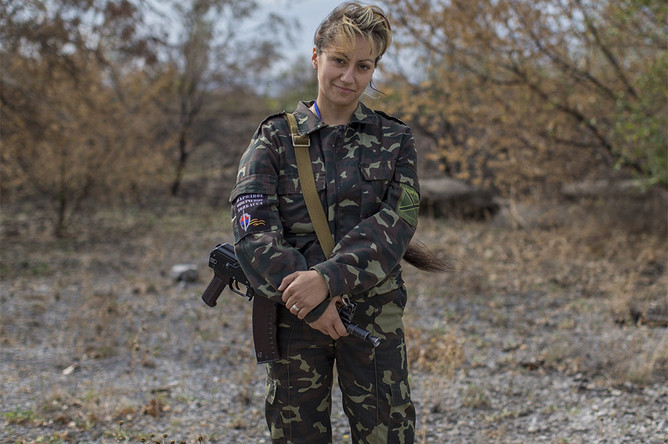 Женщина, которая воют на стороне ополченцев, позирует с винтовкой в поселке Нижняя Крынка, Донецкая область
