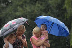 Женщины с детьми идут по улице во время сильного дождя в Москве