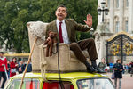 Британский комик Роуэн Аткинсон позирует в образе Мистера Бина у Букингемского дворца в честь 25-летия сериала