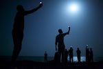 Фотограф Джон Стенмейер из США, работающий для агентства VII, снял по заказу National Geographic африканских мигрантов на побережье Джибути, пытающихся поймать слабый сотовый сигнал из Сомали. Снято в феврале 2013 года